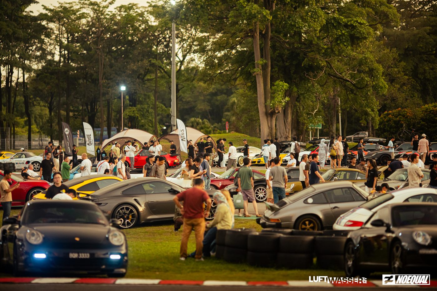 The full field of Porsches and visitors spread across the grass